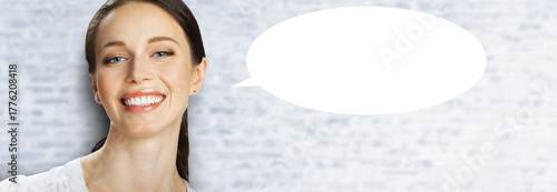 Facer portrait image - very happy, joyful, expressive smiling beautiful woman. Cute brunette hair girl stand against bricks wall background with white mockup empty speech bubble. Free ad text space.