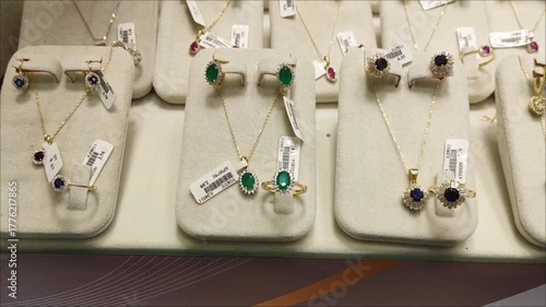 Women's gold jewelry, rings, earrings, bracelets and necklaces with precious stones in the shop window	