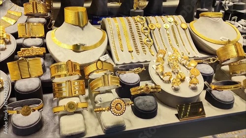 Women's gold jewelry, rings, earrings, bracelets and necklaces with precious stones in the shop window	