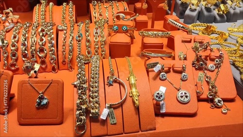 Women's gold jewelry, rings, earrings, bracelets and necklaces with precious stones in the shop window	