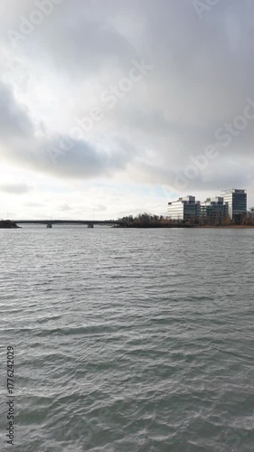 Fast drone flight just above calm water surface reflecting the sky