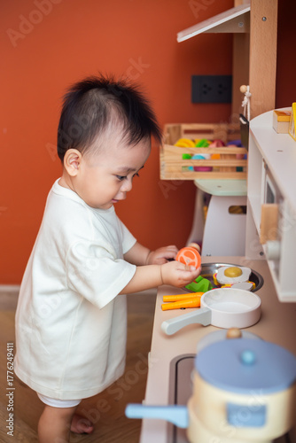 A cute little child smiles happily while playing with toys made from wood and non-toxic paint to enhance their development.