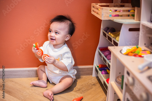 A cute little child smiles very happy while playing with toys made from wood and non-toxic paint to enhance their development.