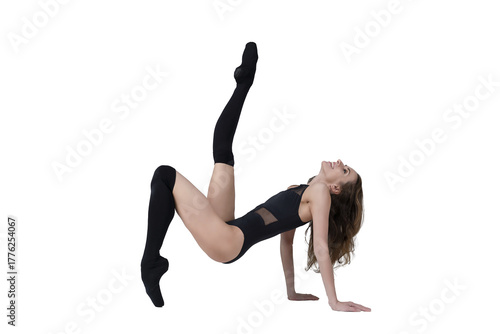ballerina with beautiful feet poses in a photo studio, a ballerina dressed in total black poses sitting on the floor