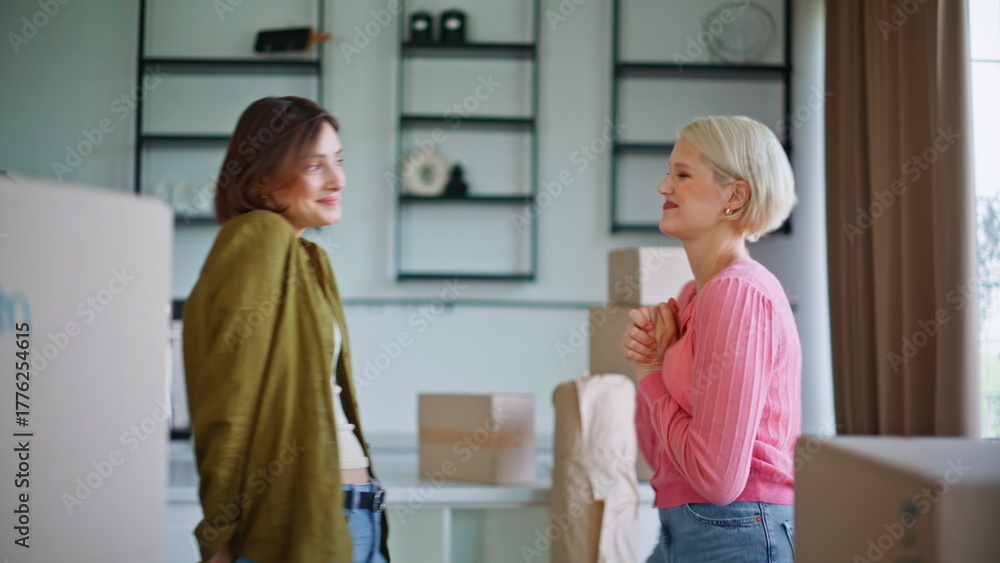 Fototapeta premium Girls examining new apartment hugging closeup. Lgbt couple house relocation