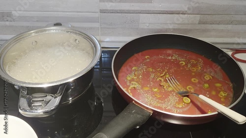 Boiling Pasta and Tomato Sauce Cooking on Kitchen Stove