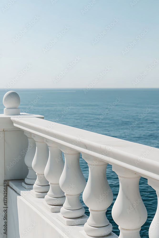 Obraz premium Marble railing overlooks the tranquil ocean under a clear blue sky. The elegant architectural detail contrasts with the vastness of the sea, offering a serene coastal view.