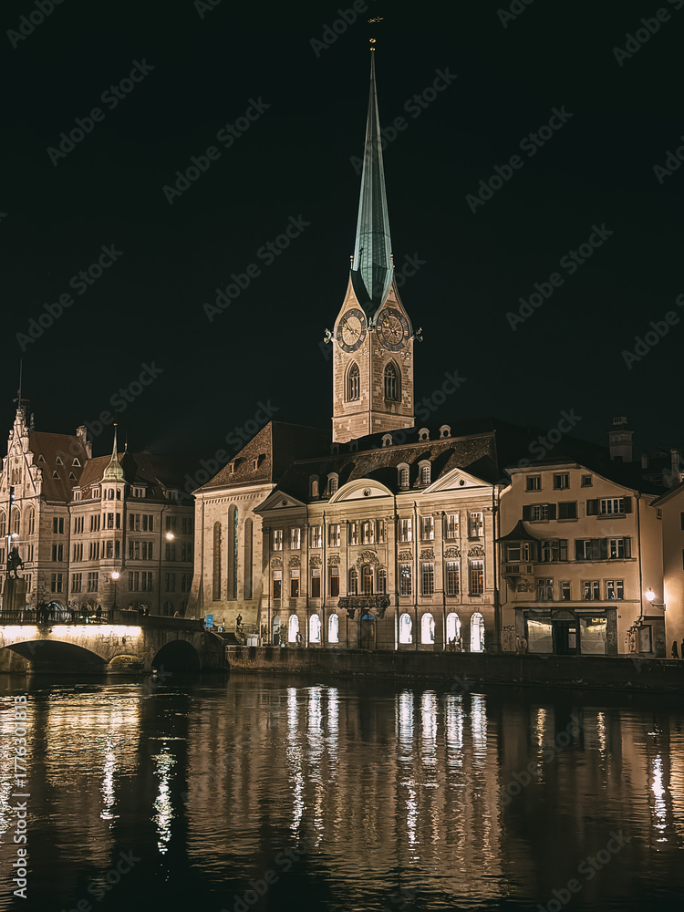 Naklejka premium Fraumunster church reflecting on limmat river at night