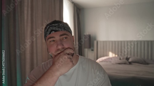 A stylish man sits in room and thinks about something.