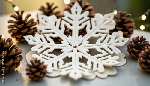 White snowflake decoration surrounded by pinecones for winter  