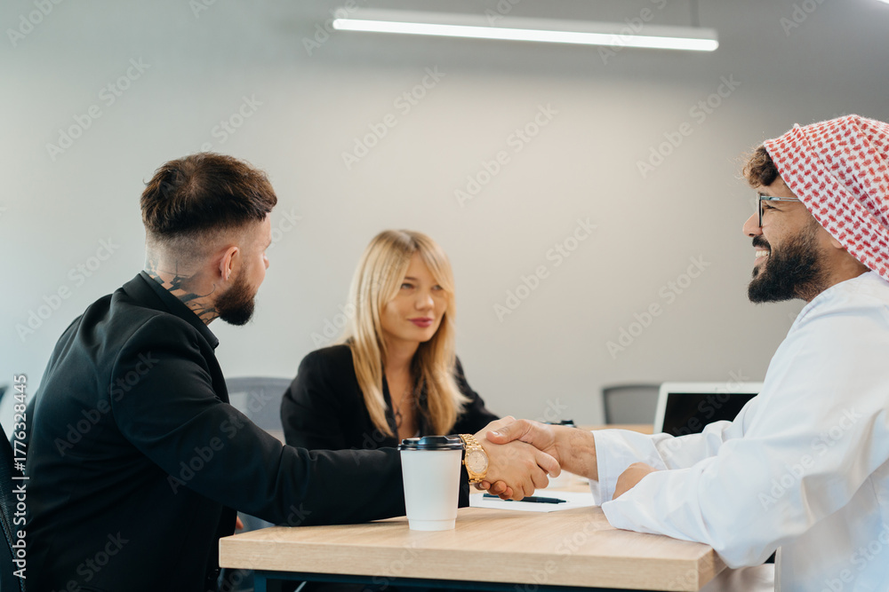 Obraz premium Diverse business partners shaking hands finalizing agreement