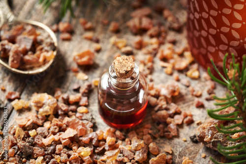 A bottle of myrrh essential oil with Christmas tree and candle