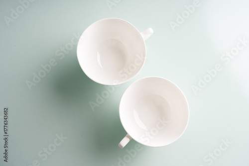 two empty coffee mugs top down on blue background