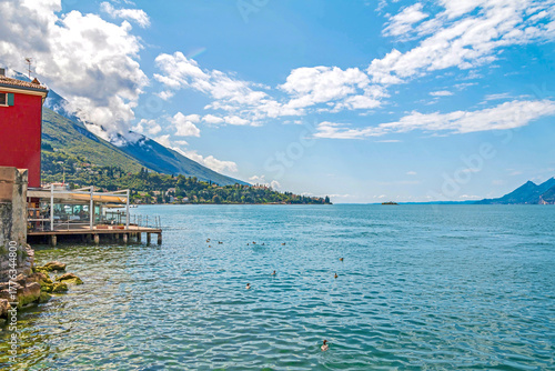 Fototapeta Naklejka Na Ścianę i Meble -  Malcesine, Italy, a picturesque town on Lake Garda, featuring charming streets, colorful lakeside buildings, historic castle views, and a lively atmosphere under sunny skies