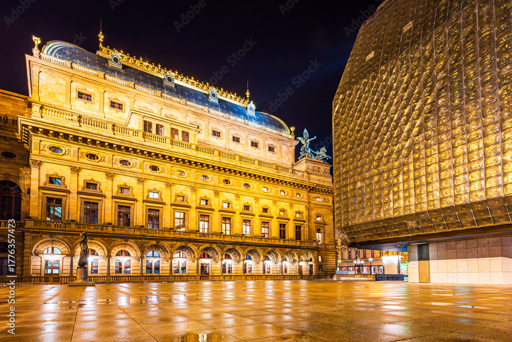 Fototapeta premium The illuminated National Theatre square in the UNESCO world heritage site city Prague in night after rain.