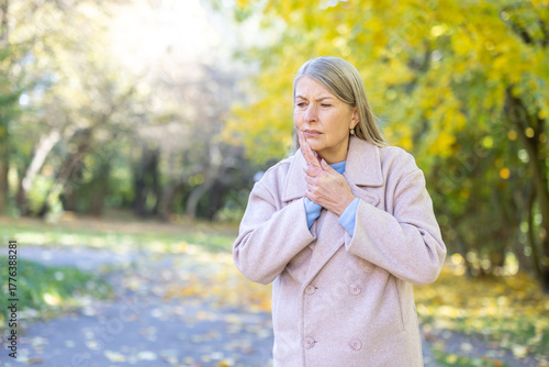 Photography Senior woman standing outdoors in a park during autumn and experiencing severe t