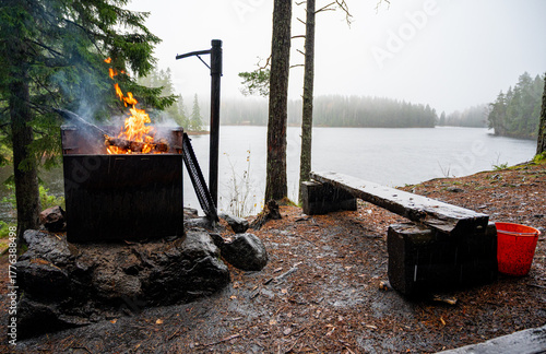 Fireplace with fire near trail in Swedish forest