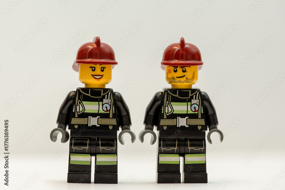 Naklejka premium Two Lego firefighter figurines on a white background.
