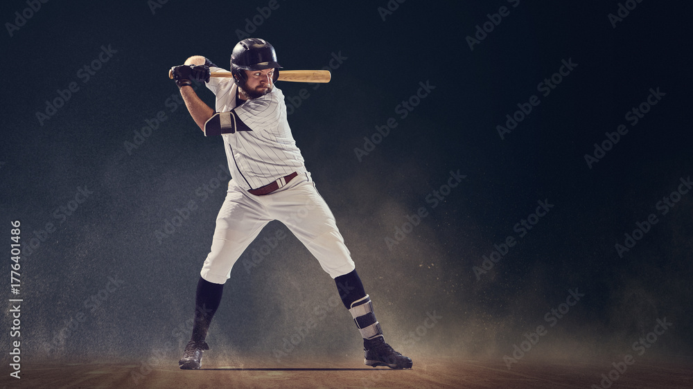Fototapeta premium Baseball batter in ready stance holding bat before swing on dusty field. Concept of anticipation, athletic discipline, professional performance for sportswear marketing and coaching materials.
