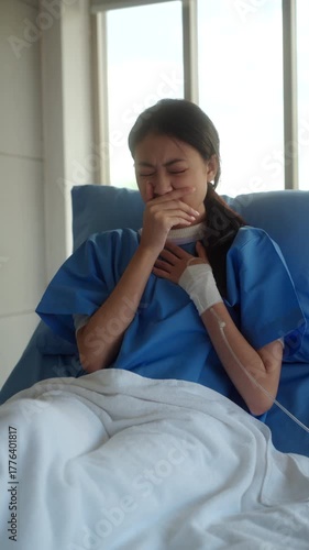 Vertical video. Sick woman patient sitting on hospital bed with fever, cough, and sore throat, feeling tired and lonely while worrying about medical expenses and treatment costs. Health insurance.
