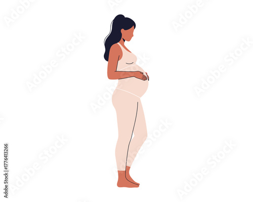Side profile of a pregnant woman standing calmly holding her belly in a white studio background