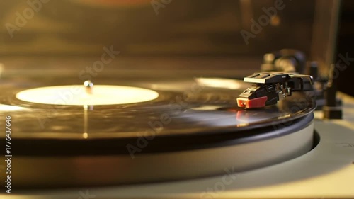 Vintage vinyl record spinning on turntable with warm light backdrop  