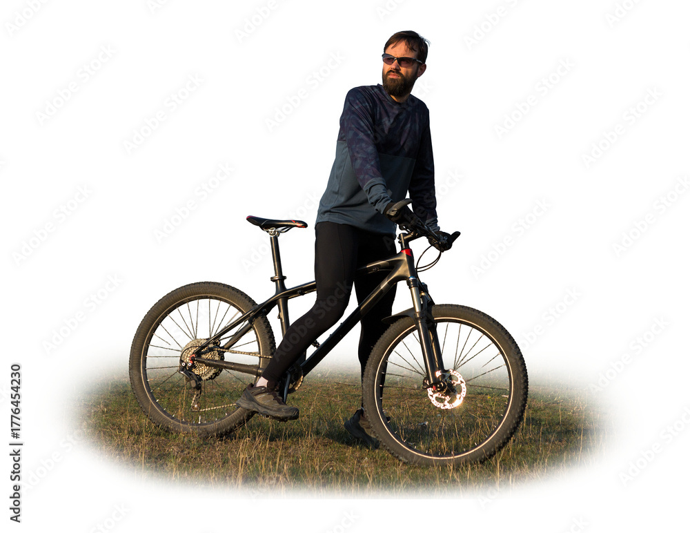 Obraz premium Cyclist in shorts and jersey on a modern carbon hardtail bike with an air suspension fork standing on a cliff against the background of fresh green spring forest