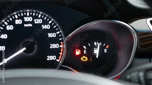 Vehicle's dashboard instrument panel showing warning lights, including the check engine and low fuel indicators, signaling a potential malfunction or the need for immediate service and refueling