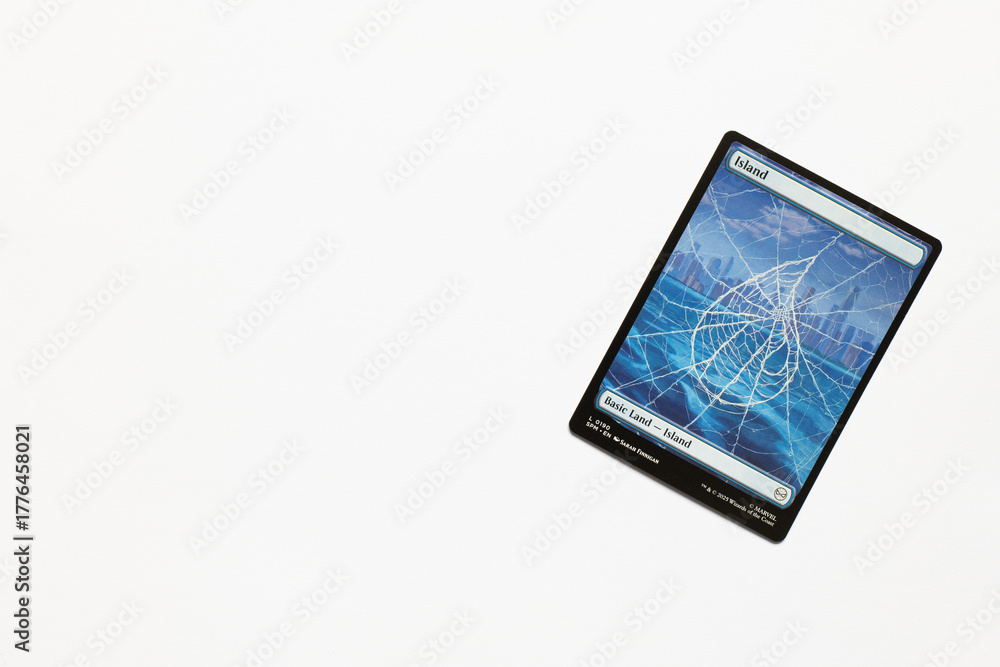 Obraz premium Bradford, UK Nov 3 2025 Basic Land Island card from the Spider-man magic the gathering card game shot isolated on a white paper background.