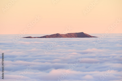 Lake District mountains poking out of clouds seen from above a temperature inversion, Great Britain, UK.