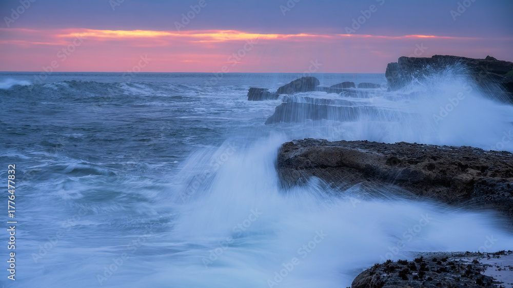 Fototapeta premium The waves crash against the rocky coast
