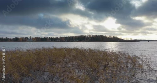 Drone flight from low over lagoon with reeds to high view toward Helsinki skyline