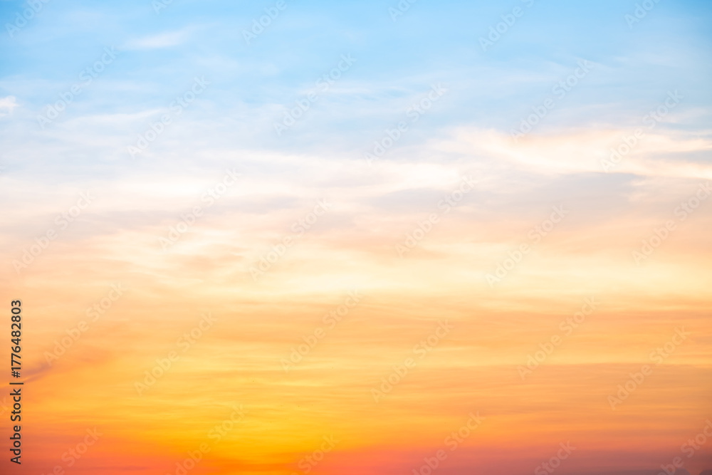 Fototapeta premium Sunset or sunrise sky with a vibrant gradient of orange, gold, and soft blue. Clear atmosphere with wispy clouds. Peaceful, natural light background. hope, freedom, new day and inspirational Concepts