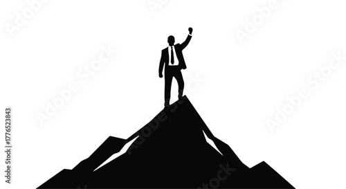 Triumphant businessman celebrates reaching mountain summit with raised fist