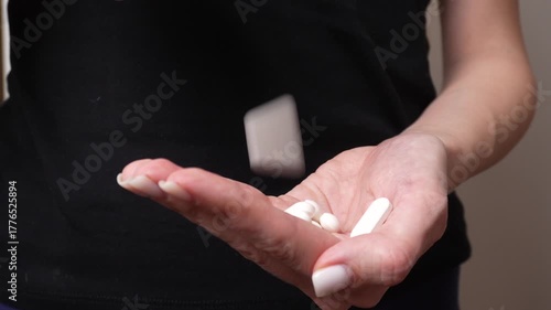 Close-up shot of woman holding white pills in her palm, representing emotional struggle, depression, or addiction concept. Symbol of sadness, stress, and mental health awareness.