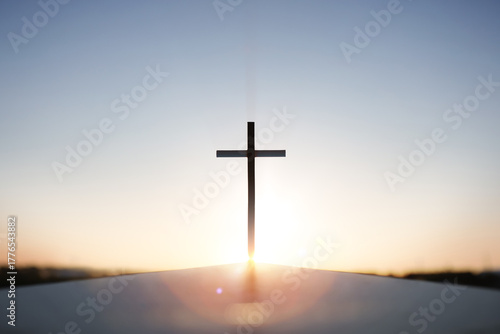 Rising New Year sunrise and the Holy Cross of Jesus Christ, with bright sky and shining sun in the background

