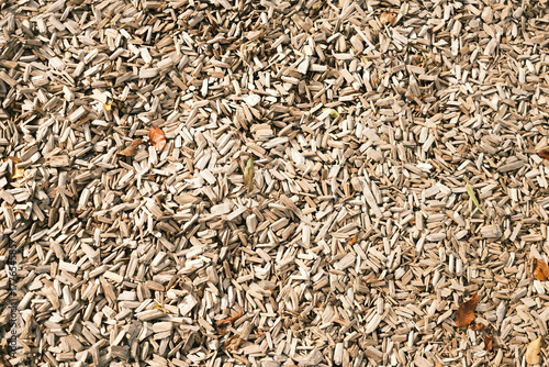 Outdoor ground covered with wood chips, shredded wood pieces used as surface covering, ideal for playgrounds or garden paths, natural brown color