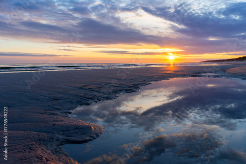 Fototapeta Naklejka Na Ścianę i Meble -  sunrise over the baltic sea with wave on the sand beach poland	