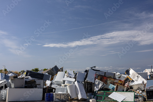 Canvas Print Stacked Pile Of Scrap Metal And Broken Chairs In A Junkyard Under A Bright Blue
