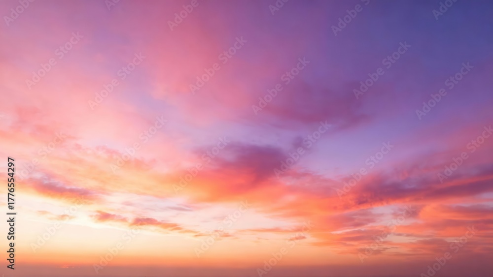 Obraz premium Vibrant pink and purple clouds streak across the sky at sunset.