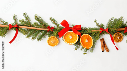 Weihnachtliche Girlande aus Tannengrün mit getrockneten Orangen, Zimtstangen und roten Schleifen