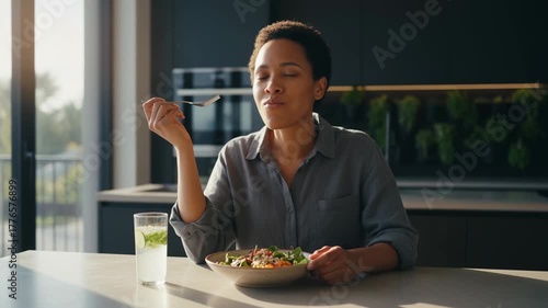 A woman enjoys a vibrant, healthy meal at home, bathed in soft, natural light, epitomizing the harmony of balanced living and nutritional well-being.