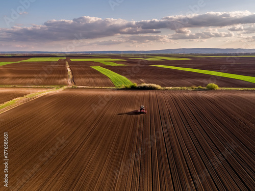 Tractor seeding field, drone aerial view farming landscape