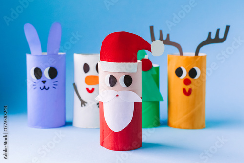 Christmas toy from toilet tube roll, paper toy santa claus, snowman, reindeer, tree rabbit on yellow background. Holiday easy kids DIY, decoration idea for winter season, home party. Children's crafts