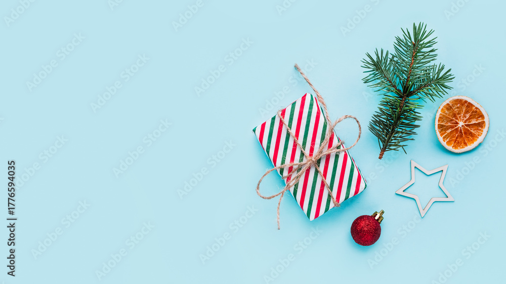 Fototapeta premium Collection of Christmas objects - gift box, frame, eve fir, dried orange, pine cone, star. New Year and winter minimal holiday frame composition. Flat lay, top view, place for text.