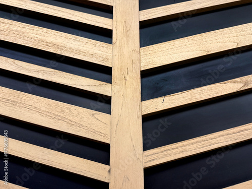 Close up of 3d carved and cut wood slat in chevron pattern with black base background. Seamless background texture