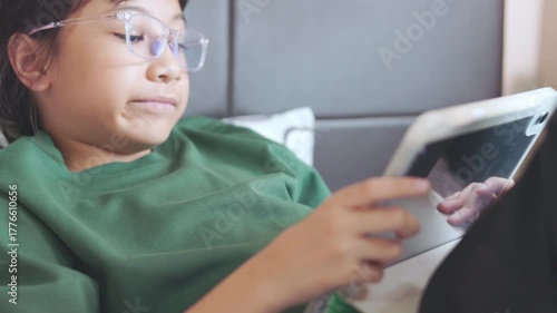 Wallpaper Mural Selective focus of Asian kid girl, playing game on tablet with concentration. Concepts of children technology use, online learning, screen time, digital lifestyle, and modern childhood education. Torontodigital.ca