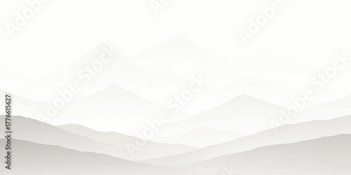 Mountain landscape view of snowy peaks in winter with clouds, mist, and sunrise silhouette