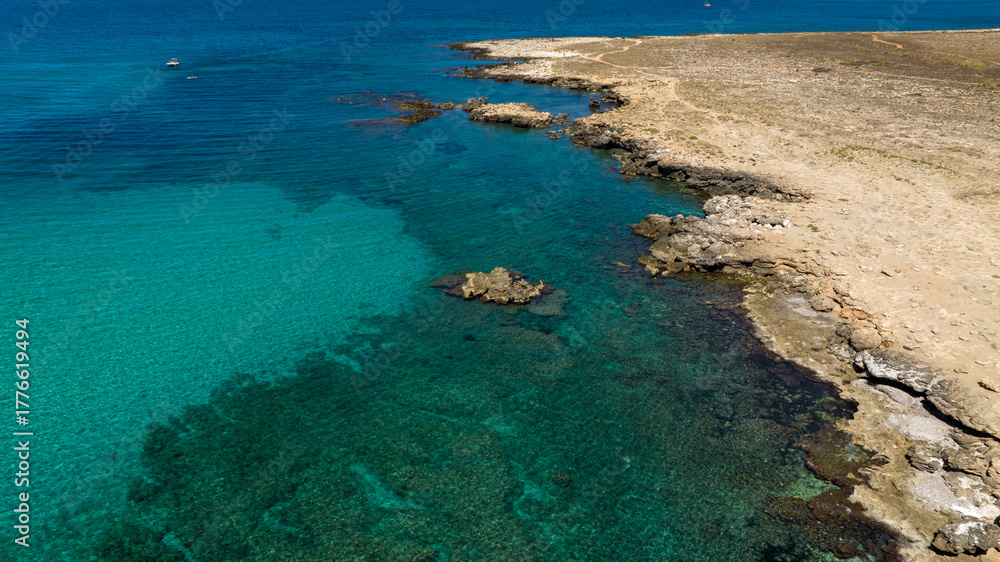 Obraz premium Aerial view of a rocky coastline facing a turquoise sea. It's located in the Zingaro Nature Reserve, near San Vito Lo Capo in Sicily, Italy.