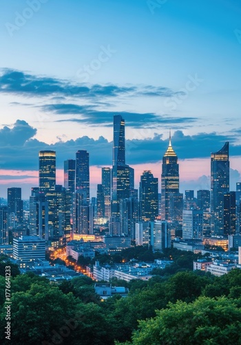 Illuminated cityscape view with modern tall buildings and green trees at night